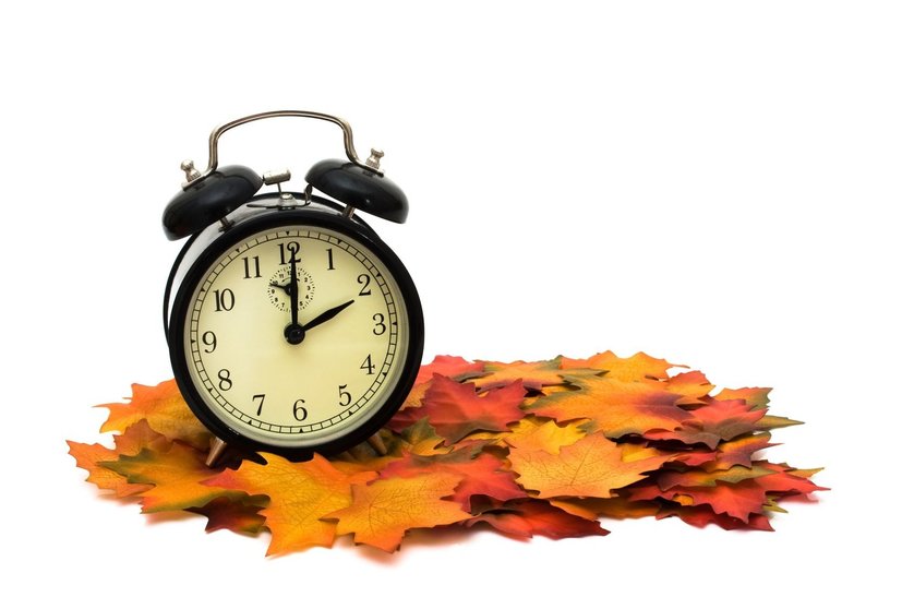 7826115 - retro black alarm clock on fall leaves, fall time change
