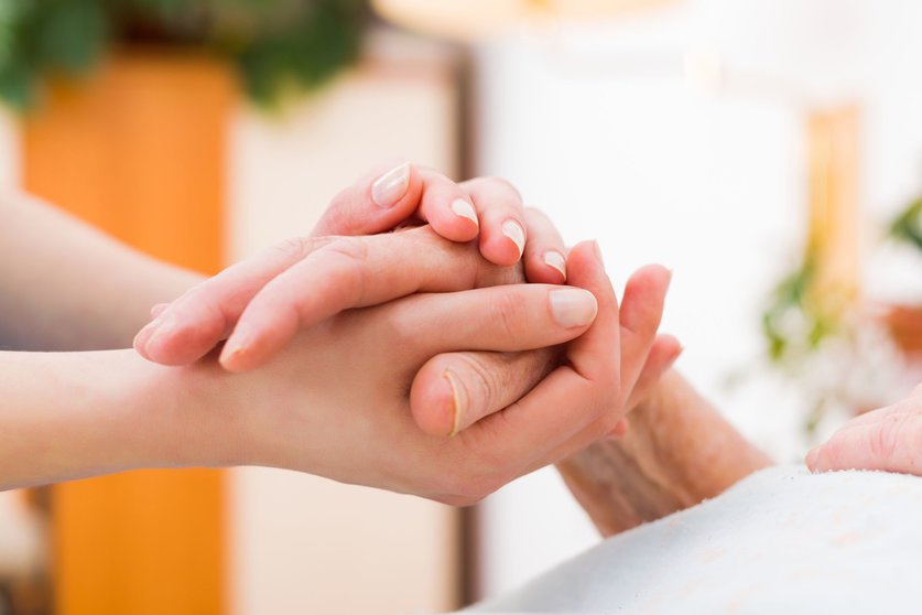 69160924 - nurse holding the hand of an elderly woman, showing sympathy and kindness.