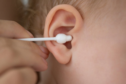 Limpieza con bastoncillo del oído de un niño
