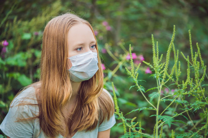 97801656 - young woman in a medical mask because of an allergy to ragweed.