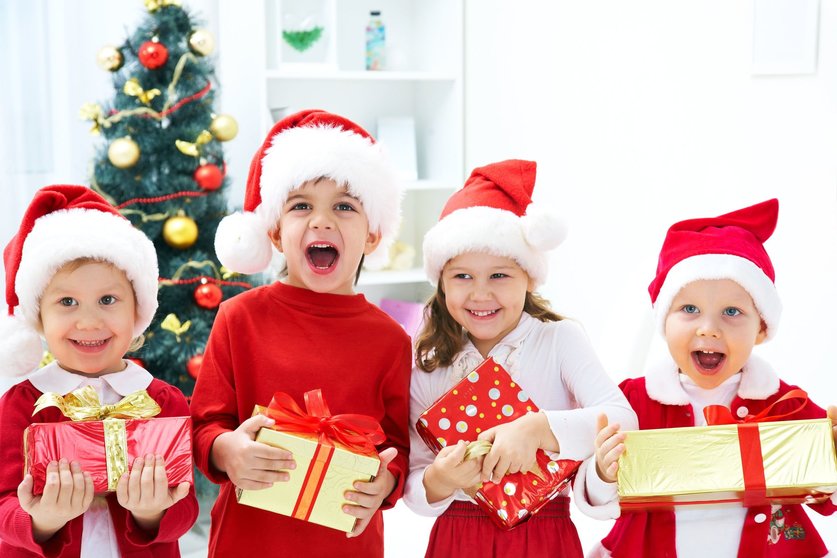 11334196 - group of four children in christmas hat with presents