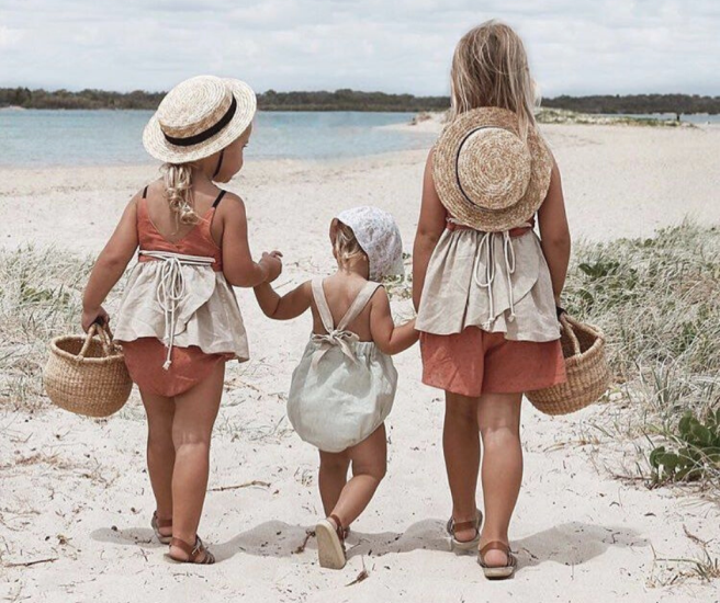 Tres niños llegando a la playa de la mano